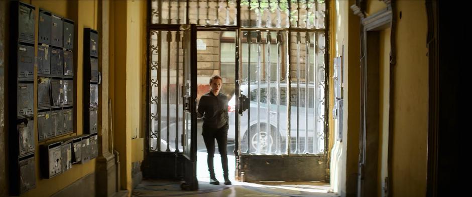 Natasha enters the building housing the safe house from the street.