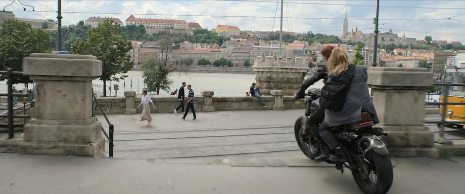 Natasha and Yelena ride down some stairs towards the tracks as a trolly approaches.