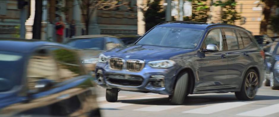 Natasha drives the stolen car around the corner onto a busy street.