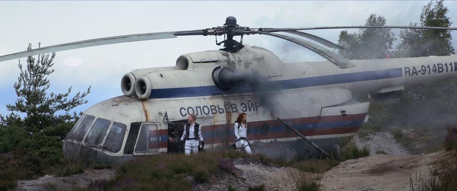 Alexei, Yelena, and Natasha climb out of the helicopter as it spews black smoke.