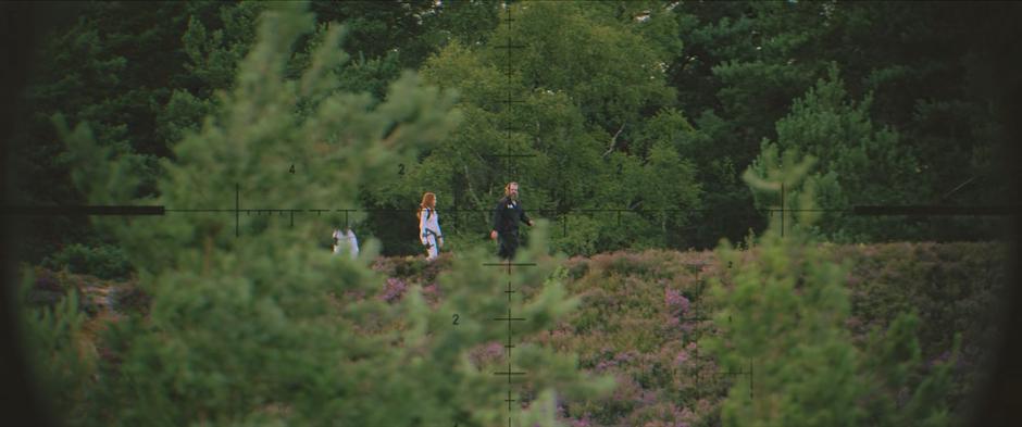 Yelena, Natasha, and Alexei are visible walking along a ridge near the farm through the scope of Melina's rifle.