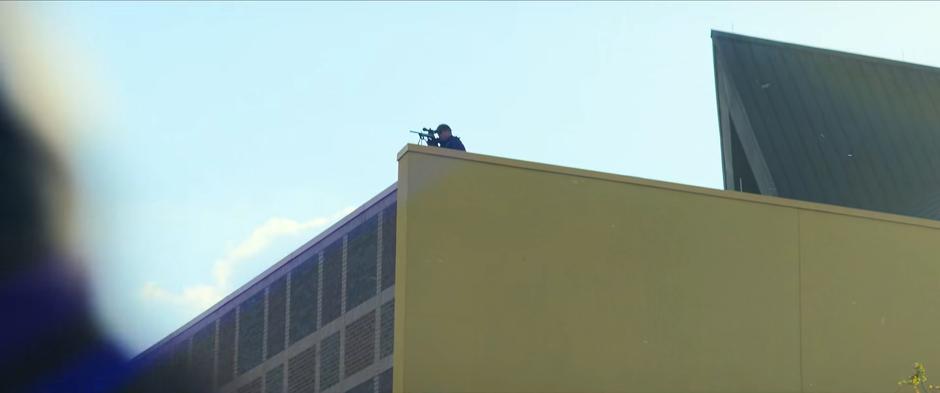 A snipes watches the operation from a nearby rooftop.