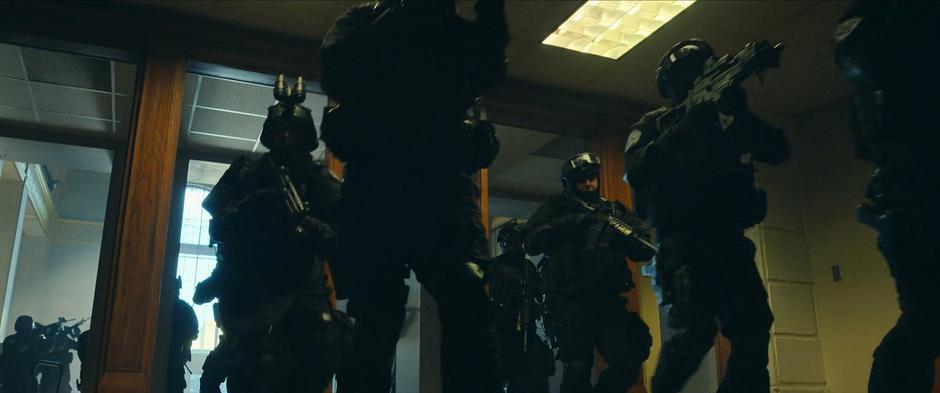 A large group of agents rush through the building.