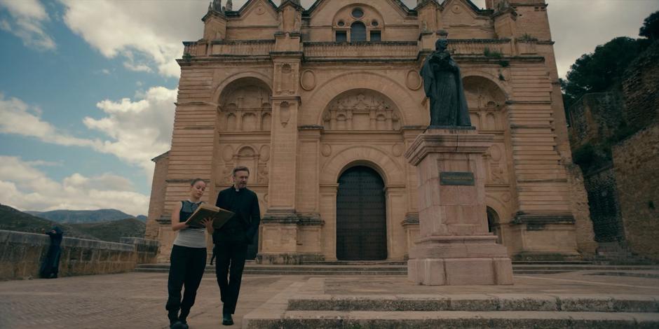 Ava reads through the history of the order while walking outside with Father Vincent.