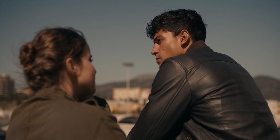 Ava stares at JC as he stares off the boat.