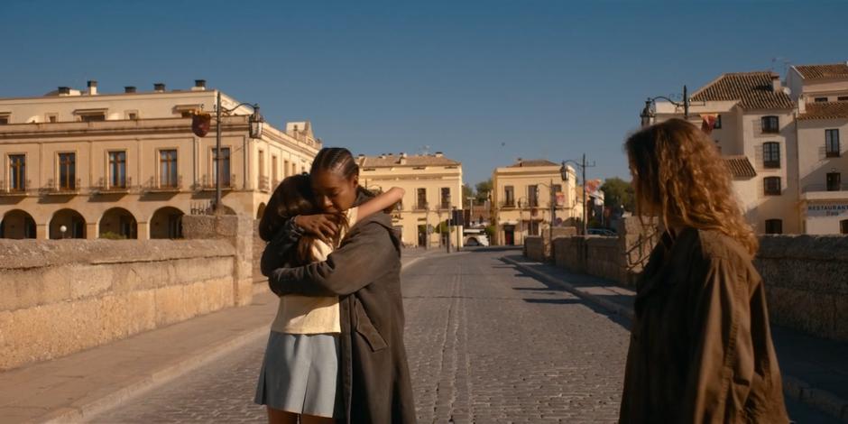 Ava watches as a young girl from the town runs up and hugs Mary.