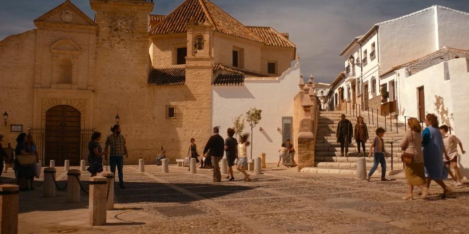 Mary and Ava walk down the stairs following the girl who calls out to two adults.