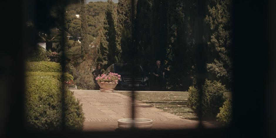 Mary and Father Vincent exit their car and approach the villa with shotguns in hand.