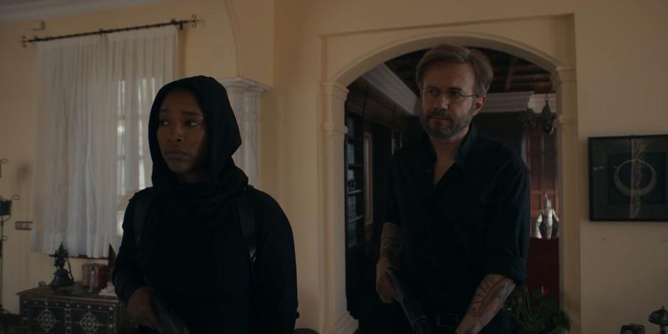 Mary and Father Vincent search through the mansion with shotguns in hand.