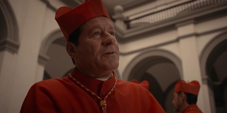 Cardinal Duretti talks to some other cardinals in the courtyard.