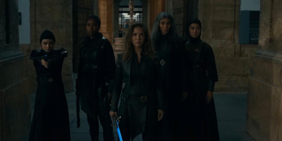 Camila, Mary, Lilith, and Beatrice face off against Adriel while Ava, standing in front of them, looks up at the wraith demons gathering around.