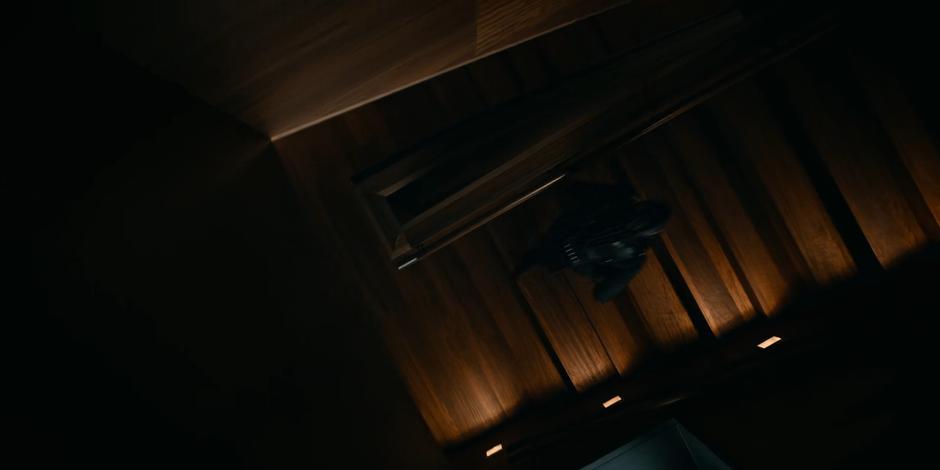 Mary runs up a set of dark wood stairs towards the control room.