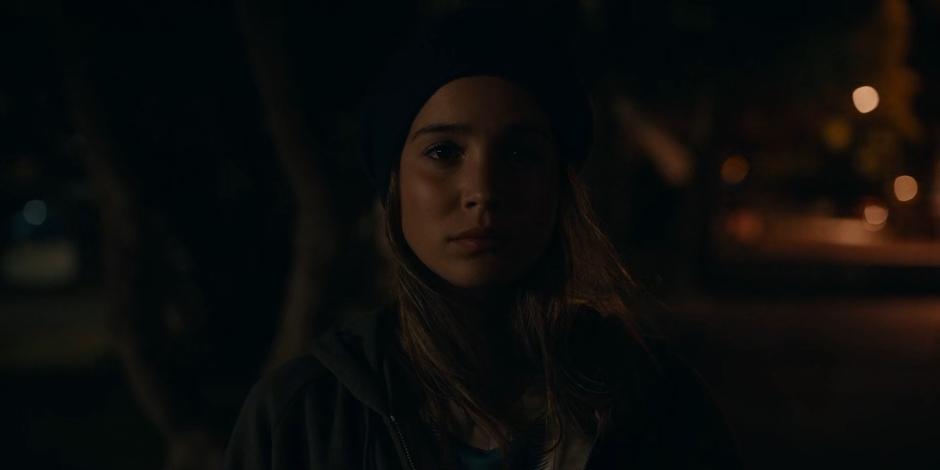 Ava looks at the front door of the orphanage at night.