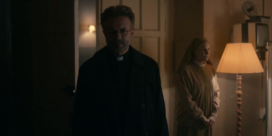 Father Vincent looks around Ava's room after being shown in by Sister Frances.