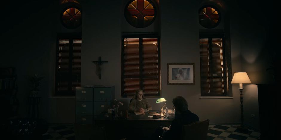 Sister Frances sits behind the desk in her office and talks to Father Vincent about Ava.