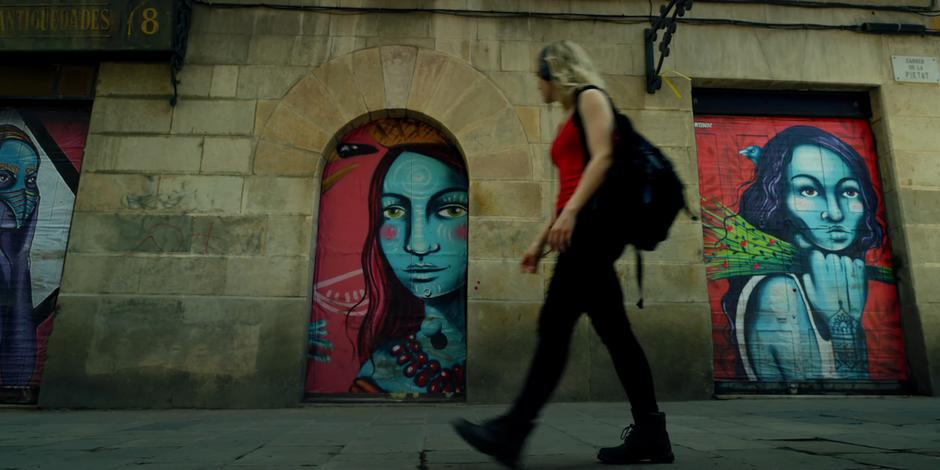 Henry walks past some murals painted on the doors.