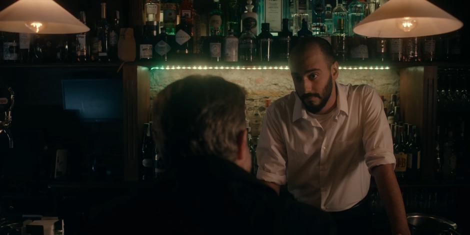 The bartender gives Father Vincent a look after the talk about demons.