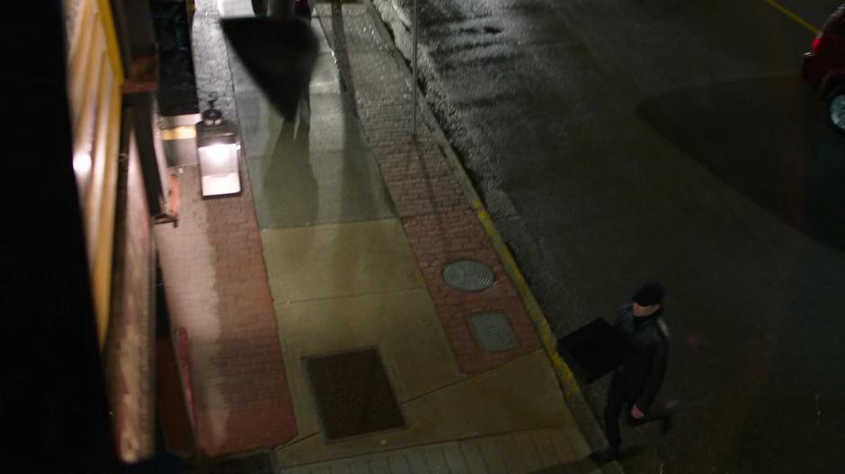 Brainy crosses the street towards an alley.