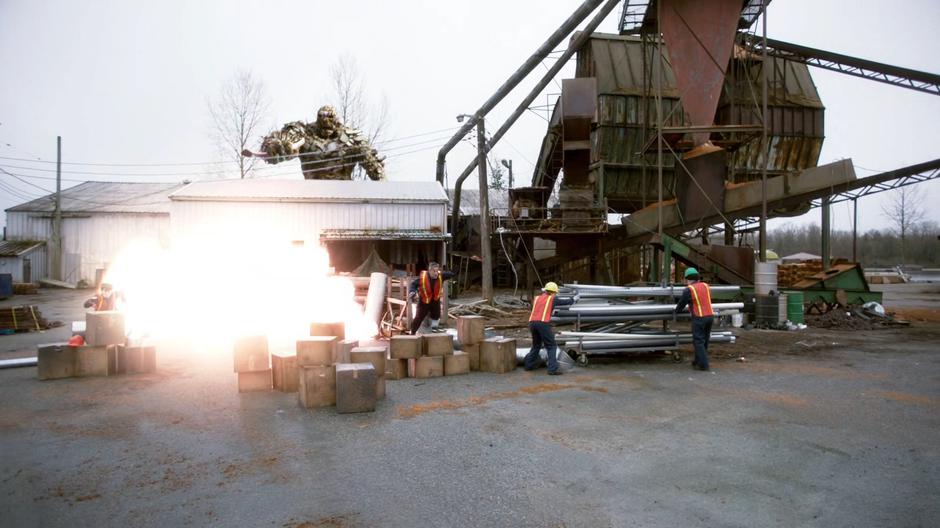 The trash monster causes an explosion among several workers.