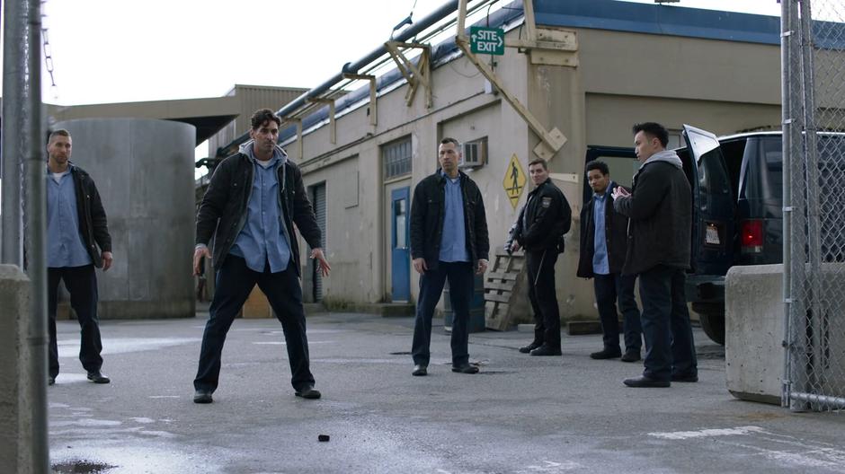 Officer Chapman and the prisoners watch as one of them uses their powers to break through the gate.