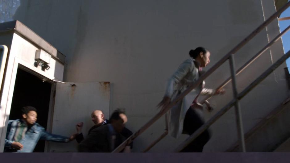 Orlando and others rush out of the building onto the balcony as the ice encroaches.