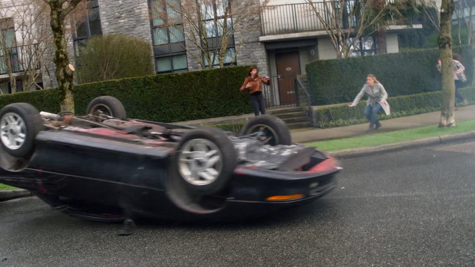 A car crashes to the ground after being thrown by the giant cat.