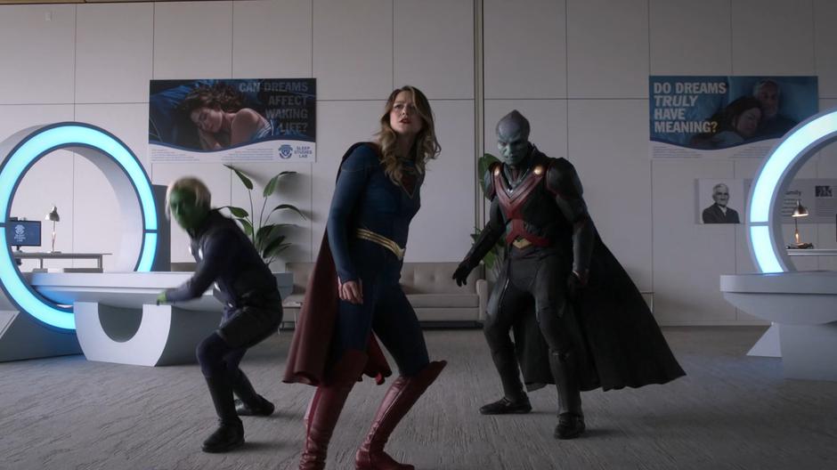 Brainy, Kara, and J'onn arrive in the dream lab and face off against Nxyly.