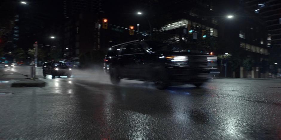 The two mercenary vehicles race through a red light towards the bridge.