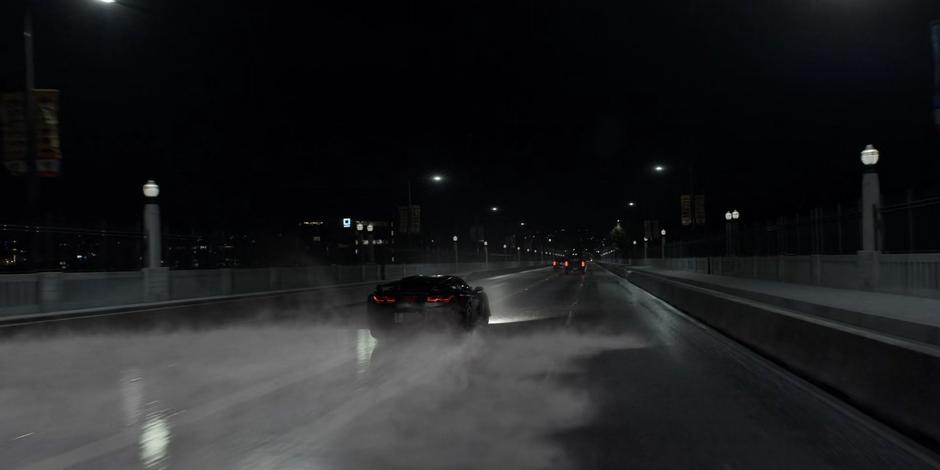 The Batmobile speeds across the ice as the two vehicles begin to drive away.