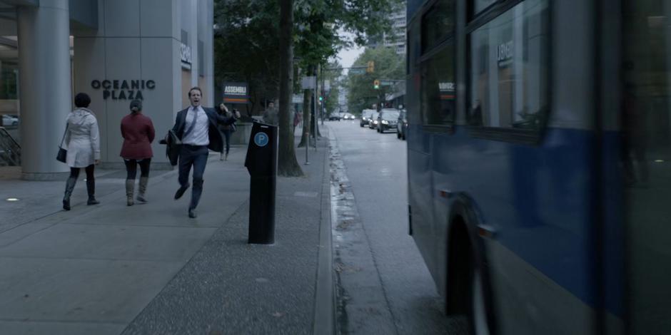 A man yells at the bus as it drives away.