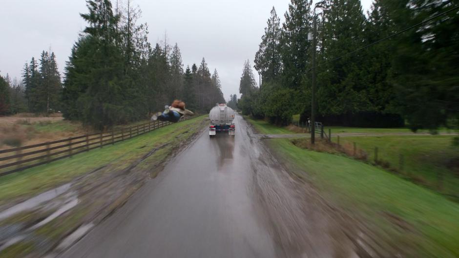 Kara flies through the air after the runaway truck.