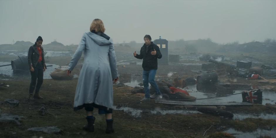 Yaz, the Doctor, and Dan regroup on the battlefield where they have just appeared.