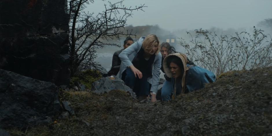 Yaz, the Doctor, Dan, and Mary Seacole kneel down out of sight of the approaching enemy soldiers.