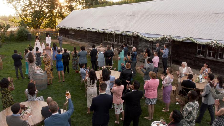 People clap as Kelly, Esme, and Alex rejoin the party after the ceremony.