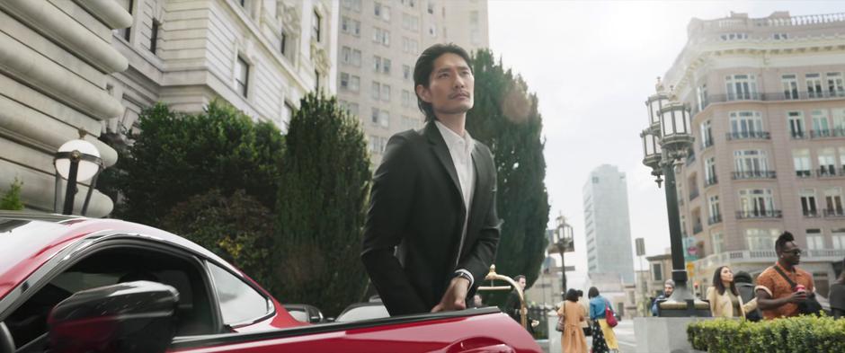 A well-dressed man exits the fancy car.
