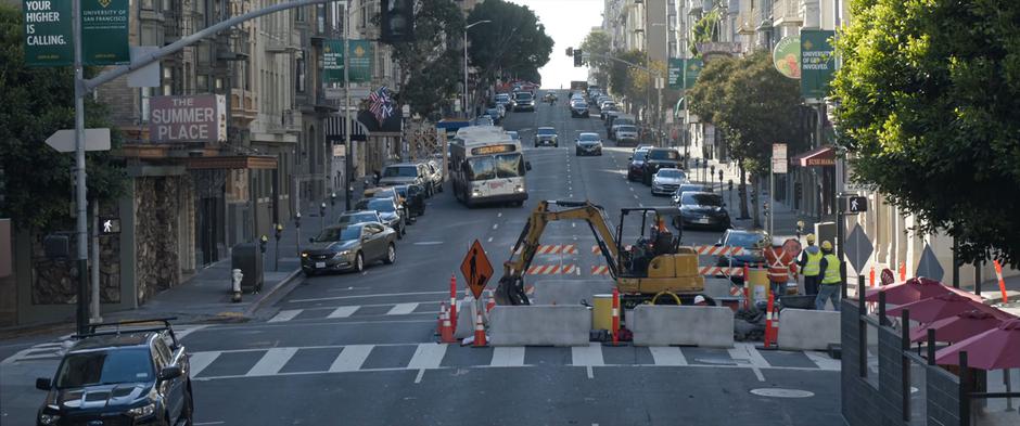 The bus swerves back and forth as it drives towards the road construction blocking several lanes of traffic.