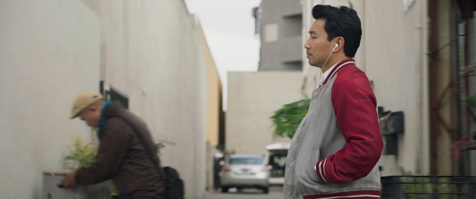 "Shaun" walks down the street listening to music.