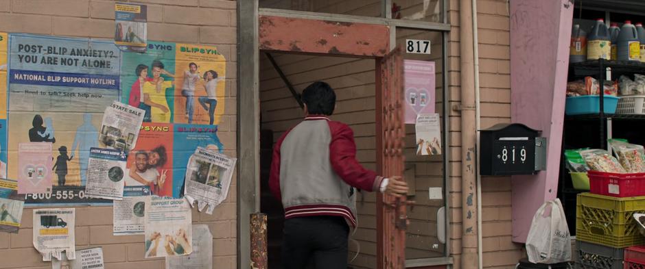 "Shaun" enters through the gate leading the stairs to Katy's apartment.