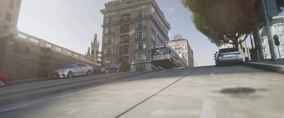 The bus flies into the air as it crests a steep hill at high speed.