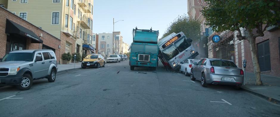 The SFC Sanitation truck and the bus slow to a stop at the end of the line of parked cars.