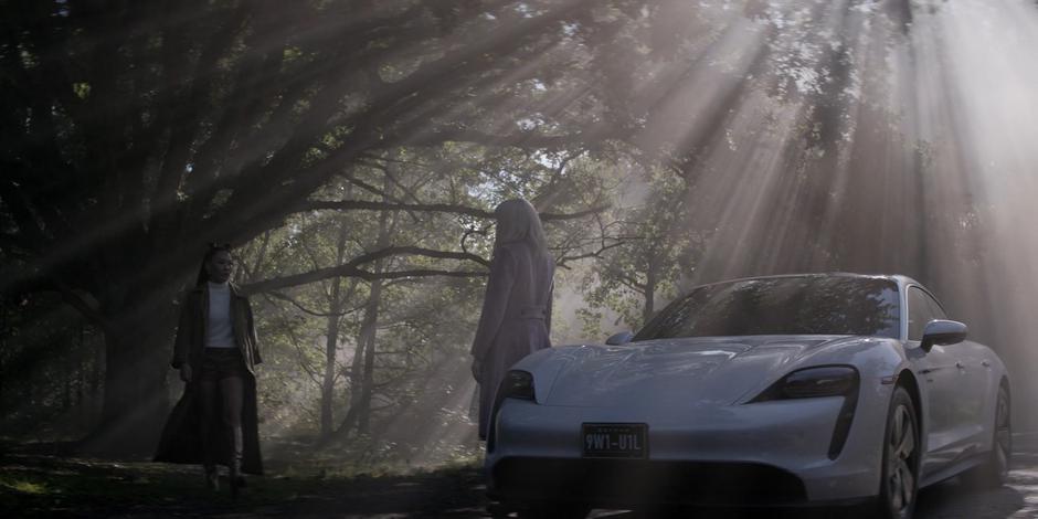 Mary approaches Alice who is standing by the stolen electric car.