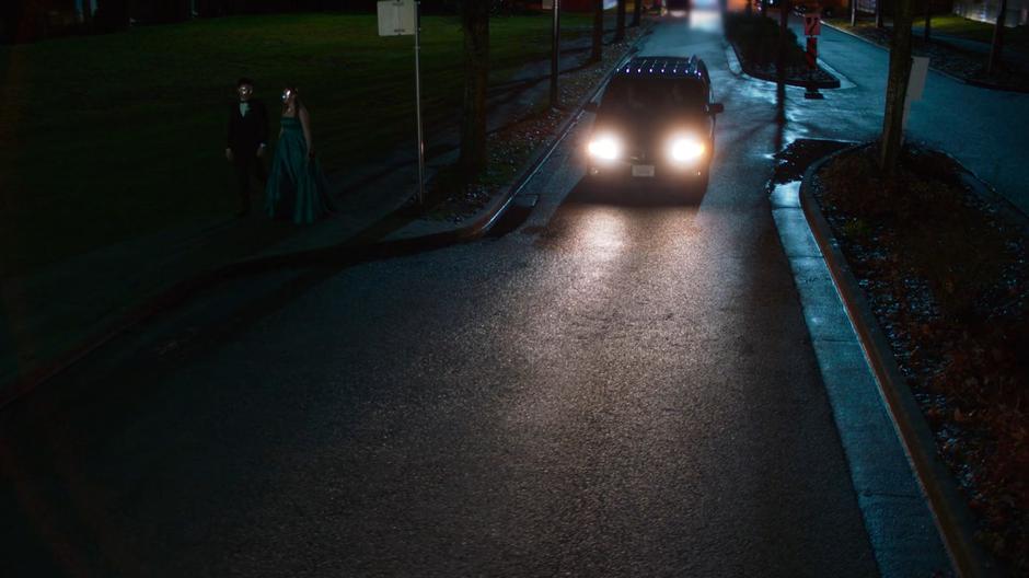 Young Kara and Alex pull up in front of the school.