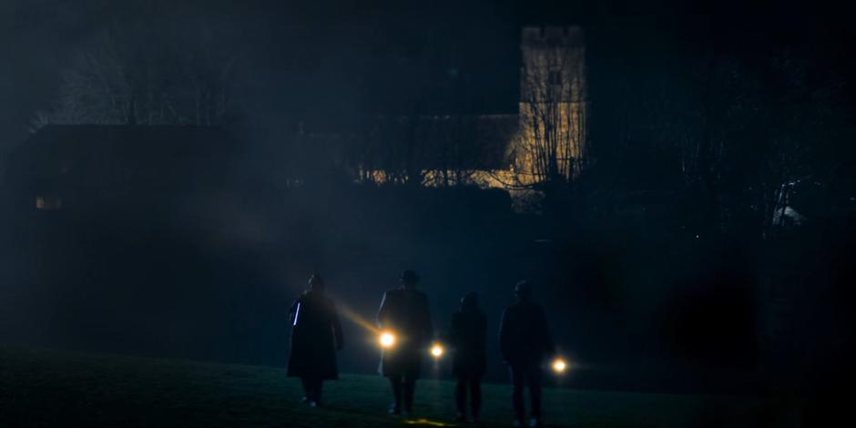 Jean, Gerald, Yaz, and Dan search through the field by torchlight.