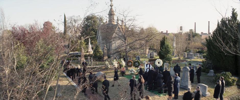 Mourners wander away at the end of Derek Bishop's funeral.