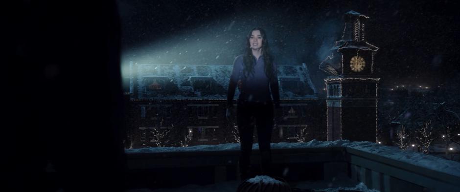 Kate is illuminated in the security guard's light as the clocktower collapses behind her.