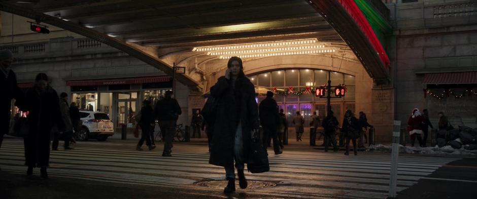 Kate crosses the street while talking to her mother on the phone.