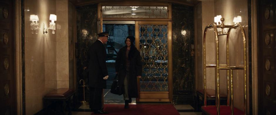 Kate greets the doorman as she walks into the lobby.