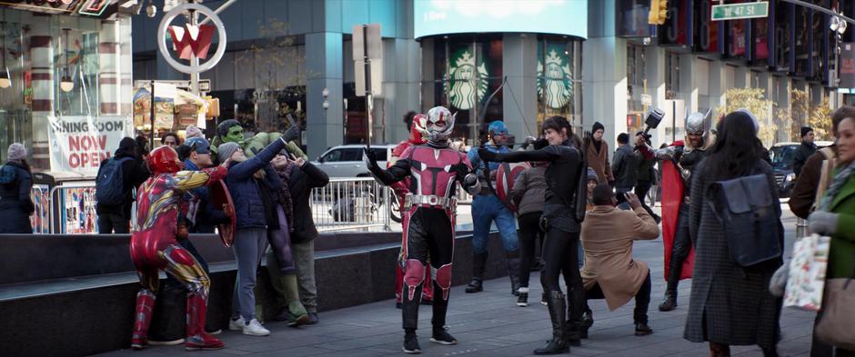 People pose with several people dressed as superheroes.