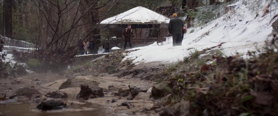 Clint walks up a path beside a stream towards the entrance of the LARP.