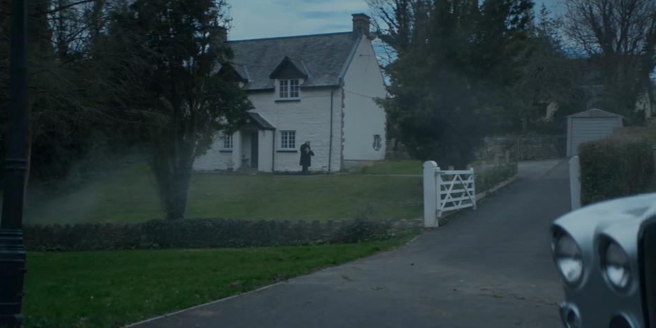 Millington walks out of his home with a newspaper in his arms.